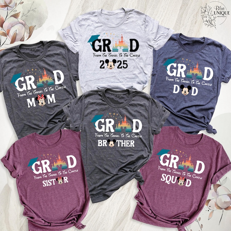 Puede incluir: Un conjunto de seis camisetas con un tema de graduaci&oacute;n. Cada camiseta presenta un dise&ntilde;o diferente con el texto "GRAD" y un personaje de Mickey Mouse. Las camisetas son de varios colores, incluyendo gris, azul, granate y gris jaspeado. El texto en las camisetas dice "From the tassel to the castle".