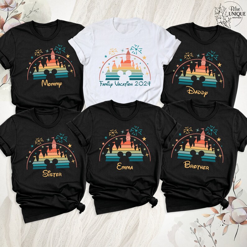 May include: Set of six black t-shirts with a retro rainbow design of the Disney castle and fireworks. Each shirt has a different name printed on it: Mommy, Family Vacation 2024, Daddy, Sister, Emma, and Brother.