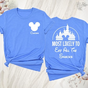 K&ouml;nnte beinhalten: Hellblaue T-Shirts mit wei&szlig;en Grafiken. Eines zeigt einen Mickey Mouse-Kopf und das Wort "Custom". Das andere hat ein Schloss-Design mit dem Text "MOST LIKELY TO Eat All The Snacks".