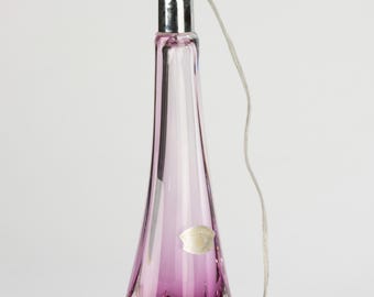 May include: A purple glass table lamp with a clear glass base and a silver metal lampshade. The lamp has a white cord and a white switch.