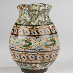 May include: A glass vase featuring a bulbous shape with a wide neck. The surface displays a complex pattern of horizontal bands in brown, light blue, and green, interspersed with intricate geometric motifs and a marbled, multicolored neck.