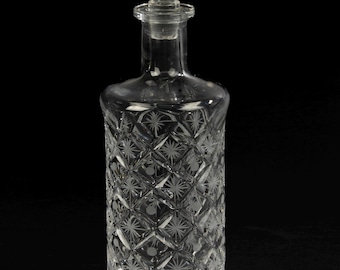 Puede incluir: Una decantador de vidrio transparente con un patrón de diamante y un tapón de cristal.