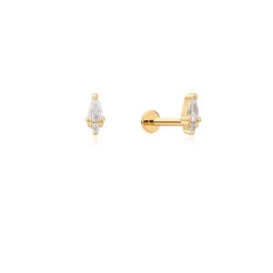 Könnte beinhalten: Ein goldener Ohrstecker mit flacher Rückseite, besetzt mit einem birnenförmigen, klaren Edelstein und einem kleineren, runden, klaren Stein an der Basis. Das Design umfasst einen geraden Stift und einen runden, flachen Verschluss aus poliertem Gold.