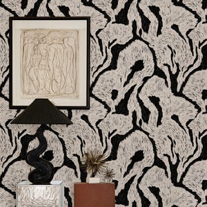 Può includere: Carta da parati con un motivo astratto in bianco e nero ad alto contrasto di forme organiche fluide. Il design è costituito da linee dense e strutturate che creano un motivo ripetitivo sulla superficie, offrendo una texture visiva audace.