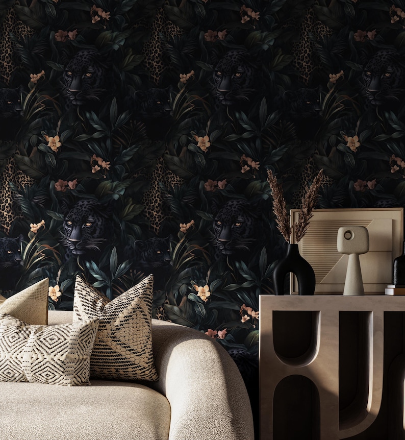 Puede incluir: Un interior de sala de estar con un sof&aacute; y una mesa auxiliar. La pared est&aacute; cubierta con papel tapiz verde oscuro con un patr&oacute;n repetitivo de jaguares negros e estampado de leopardo dorado. El sof&aacute; est&aacute; tapizado en tela beige claro y tiene dos cojines con un patr&oacute;n geom&eacute;trico. La mesa auxiliar est&aacute; hecha de madera y tiene un dise&ntilde;o &uacute;nico con estantes abiertos.
