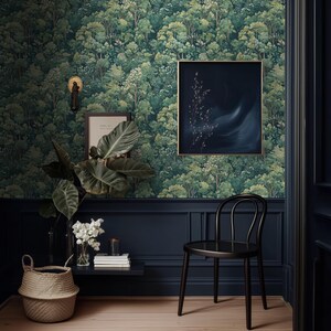 May include: A room with forest-themed wallpaper, dark blue wainscoting, and a black chair. A framed painting with a gold frame hangs on the wall. A woven basket and a plant with large leaves sit on a small shelf.