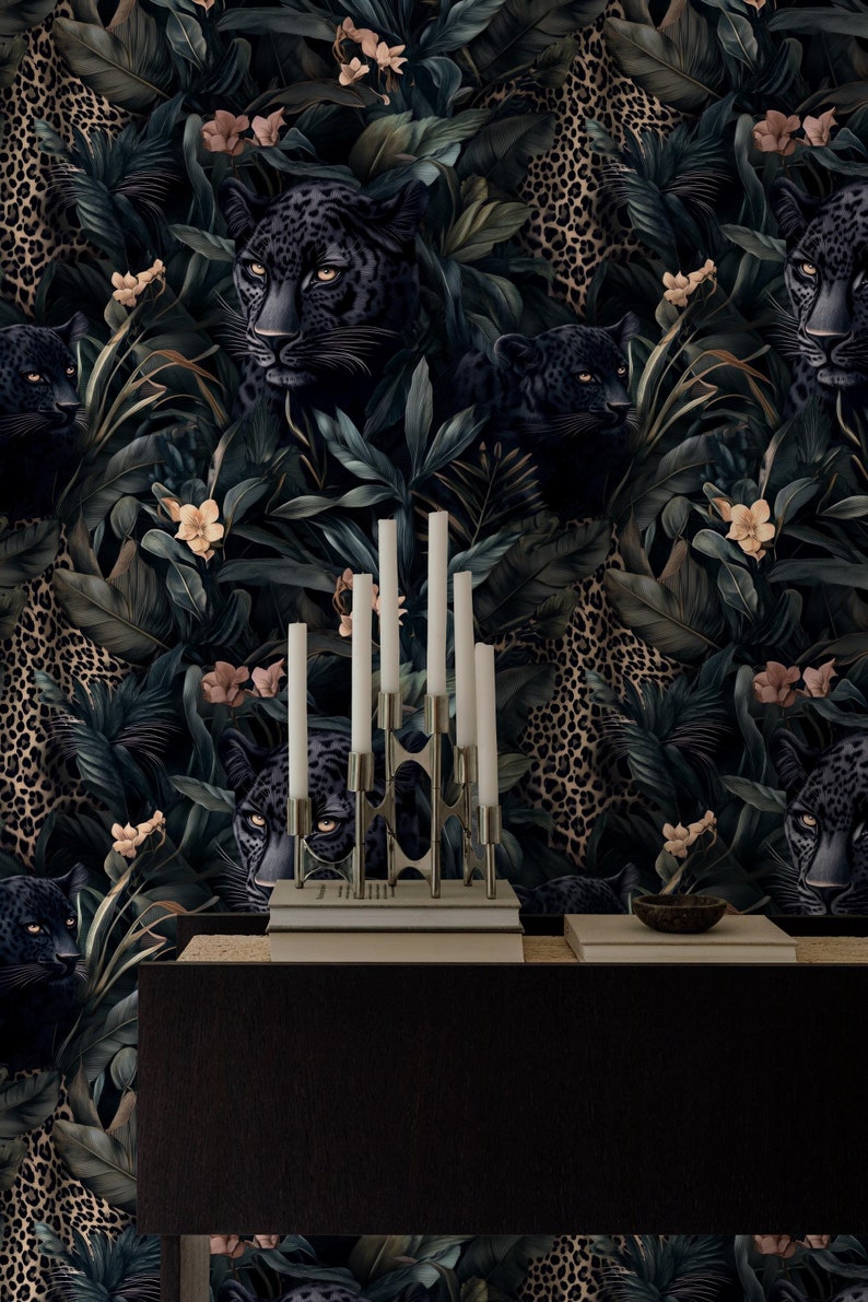 Puede incluir: Un papel tapiz verde oscuro y negro con un patr&oacute;n repetido de panteras negras y estampado de leopardo. Las panteras asoman desde detr&aacute;s de exuberantes hojas verdes y flores. Un candelero plateado con velas blancas est&aacute; en primer plano.