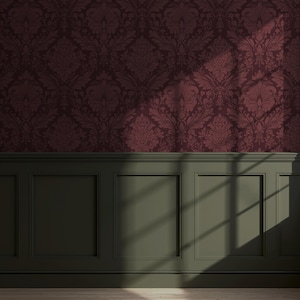 May include: Burgundy damask wallpaper above a dark green paneled wall. The wallpaper features a repeating floral pattern. Sunlight casts shadows across the wall, highlighting the textures and details of the design. The overall aesthetic is classic and elegant.
