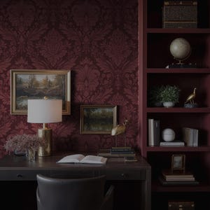 May include: A home office with a dark wood desk, a leather chair, and a burgundy damask wallpaper. The desk has a lamp, artwork, and decorative items. A built-in bookshelf displays books, a globe, and a decorative bird.