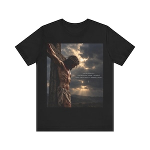 May include: A black t-shirt featuring a graphic print of a figure wearing a crown of thorns on a wooden cross against a cloudy sky. The text reads: YOUR SEEKING VALIDATION FROM A WORLD THAT CRUCIFIED A PERFECT MAN, with a small cross icon below.