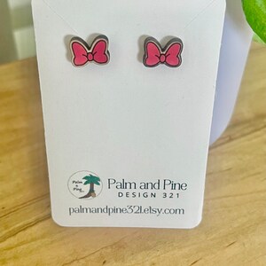 May include: A pair of pink bow earrings on a white card with the text "Palm and Pine Design 321 palmandpine321.etsy.com".