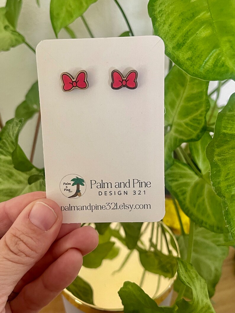 May include: A pair of pink bow earrings on a white card with the text "Palm and Pine DESIGN 321 palmandpine321.etsy.com"