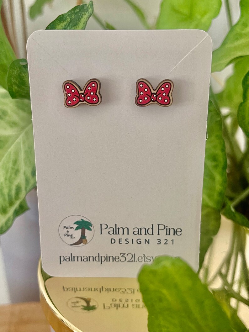 May include: A pair of red and white polka dot bow earrings on a white card with the text "Palm and Pine DESIGN 321 palmandpine321.etsy.com".