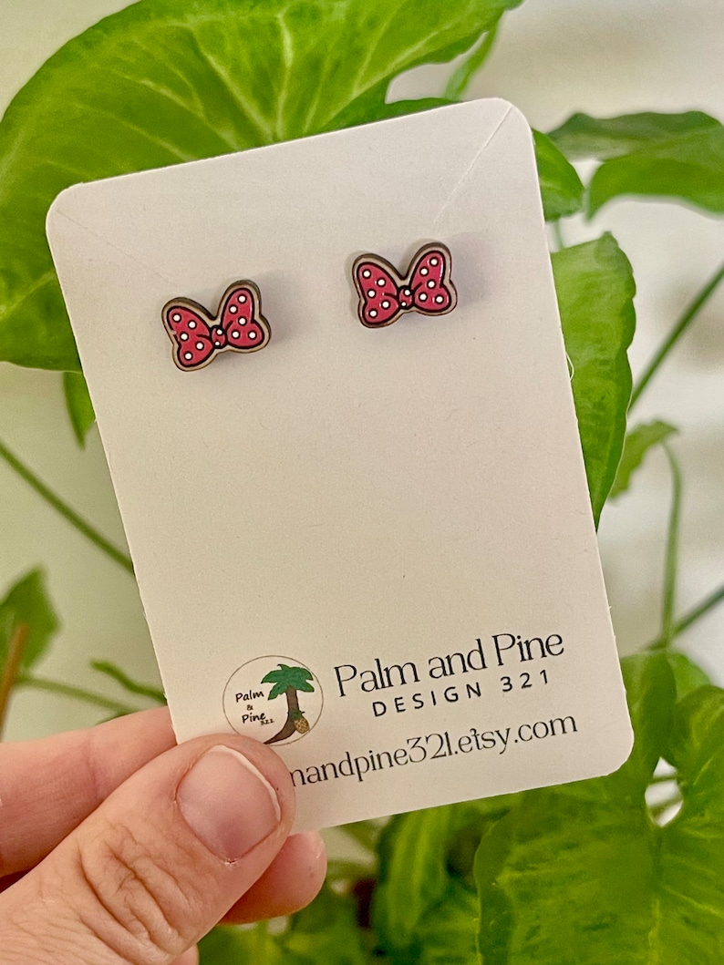 May include: A pair of red and white polka dot bow earrings on a white card with the text "Palm and Pine DESIGN 321 handpine321.etsy.com".