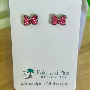 May include: A pair of red and white polka dot bow earrings on a white card with the text "Palm and Pine DESIGN 321 palmandpine321.etsy.com"