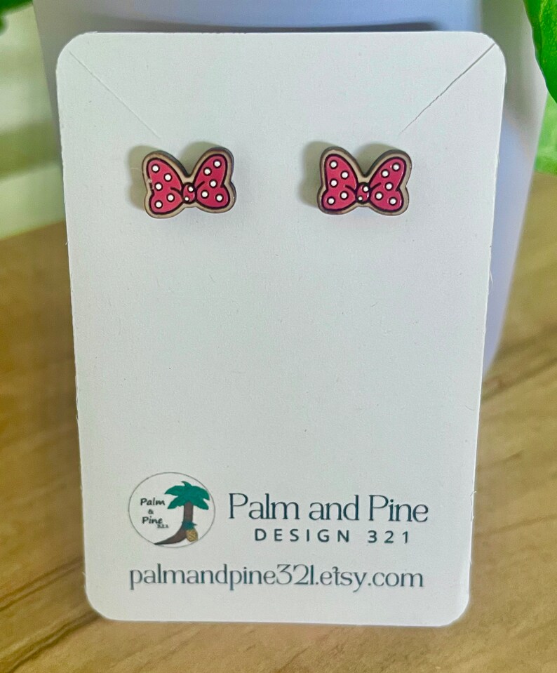 May include: A pair of red and white polka dot bow earrings on a white card with the text "Palm and Pine DESIGN 321 palmandpine321.etsy.com"