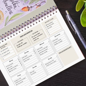 May include: A weekly planner with a beige background and black text. The planner is divided into sections for each day of the week, with space for to-do lists, notes, and a section for weekly goals. The planner also includes a section for "Weekly Reward" and "Weekly Progress".