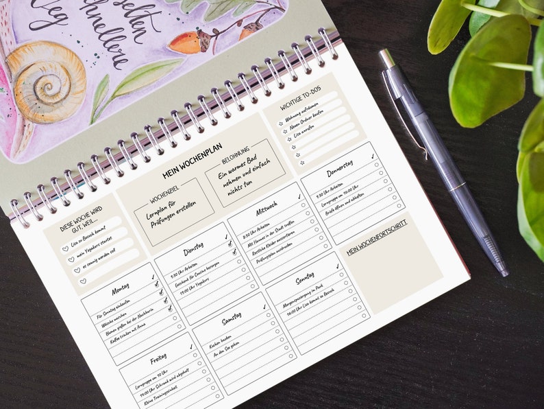 May include: A weekly planner with a beige background and black text. The planner is divided into sections for each day of the week, with space for to-do lists, notes, and a section for weekly goals. The planner also includes a section for "Weekly Reward" and "Weekly Progress".