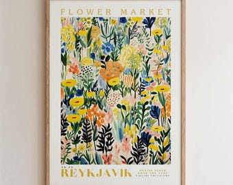 Pode incluir: Uma impressão artística emoldurada com um design floral colorido. A impressão exibe o texto "FLOWER MARKET" e "REYKJAVIK". A obra de arte apresenta uma variedade de flores em tons de amarelo, azul, laranja e rosa, criando uma composição vibrante.