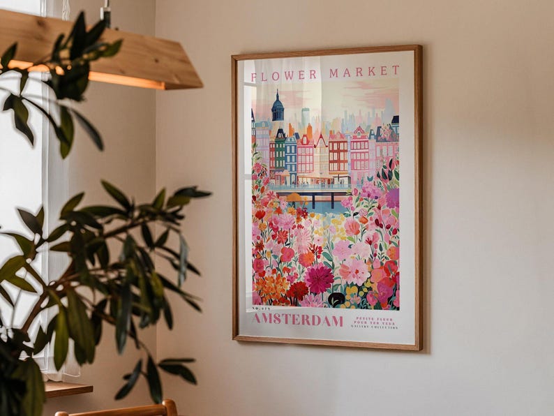 a framed poster of Amsterdam's flower market, with a cityscape and colorful flowers in the background.