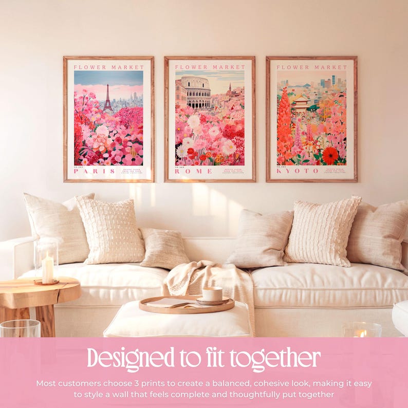 a cozy living room with three framed prints of flower market scenes hanging on the wall. The prints depict Paris, Rome, and Kyoto, creating a harmonious and visually appealing display. The arrangement of the prints and the matching pillows on the couch contribute to a cohesive and stylish atmosphere in the room.