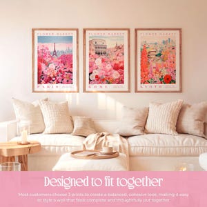 a cozy living room with three framed prints of flower market scenes hanging on the wall. The prints depict Paris, Rome, and Kyoto, creating a harmonious and visually appealing display. The arrangement of the prints and the matching pillows on the couch contribute to a cohesive and stylish atmosphere in the room.