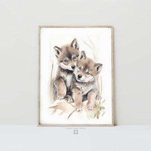 Op de afbeelding: Waterverf schilderij van twee wolf pups die knuffelen. De pups zijn bruin en grijs met blauwe ogen. De achtergrond is lichtbruin met groen gebladerte.