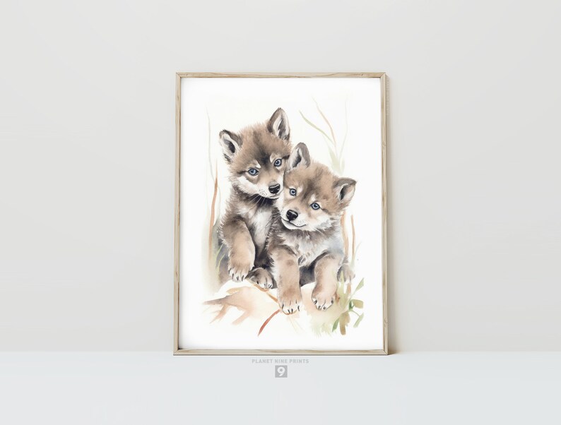 Op de afbeelding: Waterverf schilderij van twee wolf pups die knuffelen. De pups zijn bruin en grijs met blauwe ogen. De achtergrond is lichtbruin met groen gebladerte.