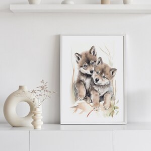 Op de afbeelding: Waterverf schilderij van twee wolf pups die knuffelen. De pups zijn bruin en grijs met blauwe ogen. De achtergrond is lichtgroen en wit.