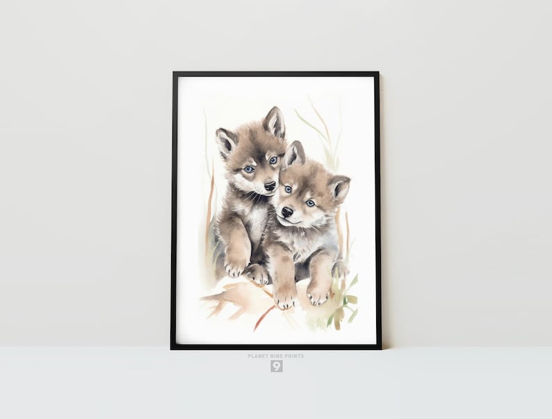 Op de afbeelding: Waterverf schilderij van twee wolf pups die knuffelen. De pups zijn bruin en grijs met blauwe ogen. De achtergrond is een lichte was van waterverf met groen gebladerte.