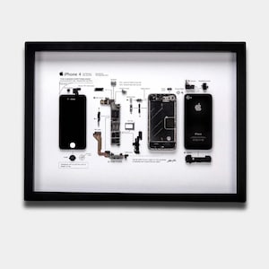 May include: A black framed display featuring a deconstructed iPhone 4 with its internal components, including the logic board, camera, and battery, laid out on a white background. Text labels identify each part, with the phone's dimensions listed as 4.5" x 2.31" x 0.37".
