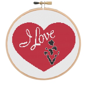 May include: A red heart with the word "Love" written in white cursive on a white background. The heart is surrounded by a wooden embroidery hoop.