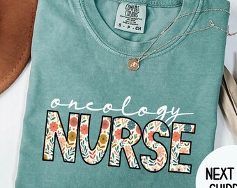 May include: Light green t-shirt with the text "oncology nurse" in white with floral accents. The text is in a large, bold font.