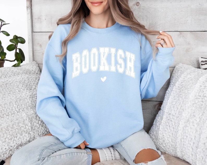 May include: A light blue sweatshirt with the word "BOOKISH" in white letters and a small white heart below it.