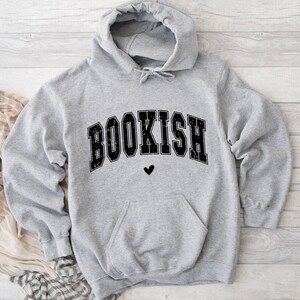 May include: Gray hooded sweatshirt with the word "BOOKISH" in black block letters with a small black heart below the word.