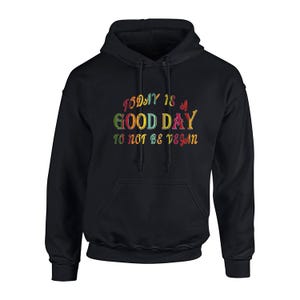Op de afbeelding: Zwarte hoodie met een voorzak en trekkoord. De hoodie heeft de tekst "TODAY IS A GOOD DAY TO NOT BE VEGAN" in kleurrijke, geborduurde letters. Een casual, comfortabel kledingstuk.