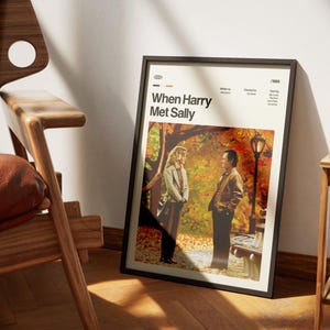 May include: A framed poster for the movie "When Harry Met Sally" leans against a wall. The poster features a scene with two people in a park setting with fall foliage. The poster has a black frame and the movie title is displayed at the top.