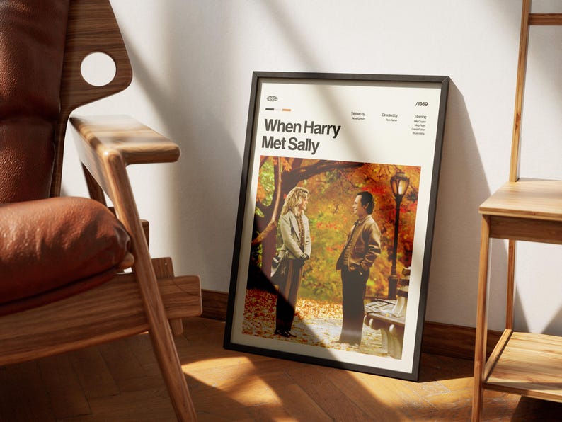 May include: A framed poster for the movie "When Harry Met Sally" leans against a wall. The poster features a scene with two people in a park setting with fall foliage. The poster has a black frame and the movie title is displayed at the top.