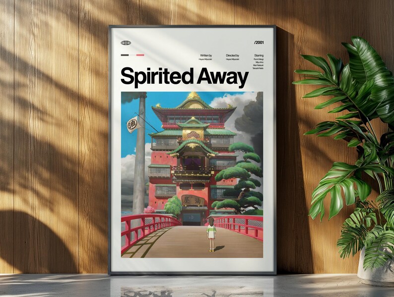 Może przedstawiać: Oprawiony plakat z tytułem "Spirited Away" w białych literach. Grafika przedstawia czerwony most prowadzący do wielopoziomowego budynku, z postacią idącą w jego kierunku. Plakat jest w czarnej ramie.