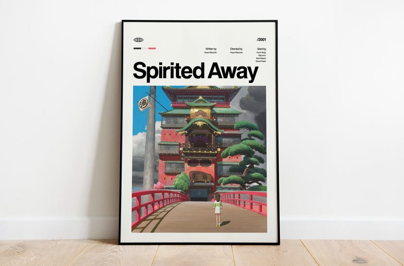Może przedstawiać: Oprawiony plakat z filmu animowanego "Spirited Away". Grafika przedstawia żywą scenę z czerwonym mostem, szczeg&oacute;łowym budynkiem i postacią zmierzającą w jego kierunku. Plakat zawiera tytuł i napisy filmu.