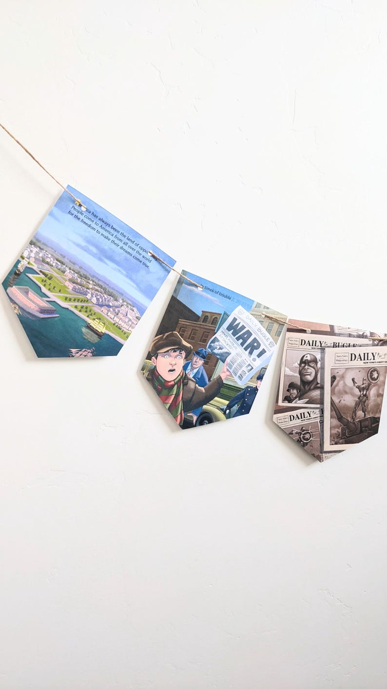 Puede incluir: Una hilera de banderines con im&aacute;genes de un horizonte urbano, un hombre con sombrero sosteniendo un peri&oacute;dico con la palabra "&iexcl;GUERRA!" impresa en &eacute;l, y un superh&eacute;roe con un traje rojo, blanco y azul. Los banderines est&aacute;n colgados en una pared blanca.