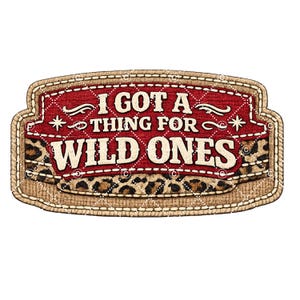 Puede incluir: Un parche rectangular con el texto "I GOT A THING FOR WILD ONES". El parche tiene un fondo rojo con costuras blancas y un borde de estampado de leopardo. Los bordes son de color canela con costuras blancas.