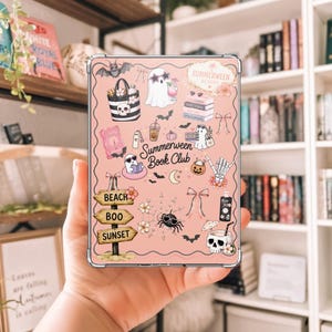 May include: A rectangular tablet case with a light pink background featuring various illustrations including ghosts, a skull, bats, a spider with sunglasses, a beach sign reading BEACH BOO SUNSET, and the text Summerween Book Club in the center.