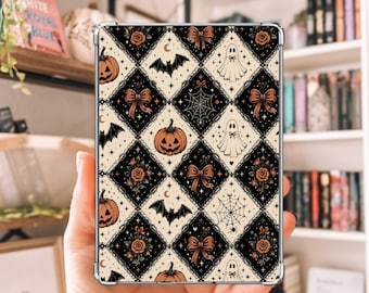 May include: A rectangular tablet case featuring a repeating diamond pattern in black and cream. The design includes illustrations of orange jack-o'-lanterns, white ghosts, black bats, spiderwebs, and brown bows, accented with small stars and crescent moons.