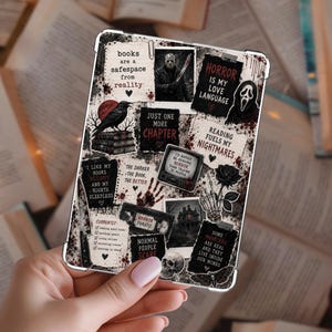 May include: A rectangular e-reader case featuring a collage of horror-themed imagery and text. Elements include a skull, a raven, a rose, a moth, a haunted house, and characters from horror films. Text includes phrases like books are a safespace from reality.