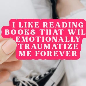 Puede incluir: Pegatina rosa con texto blanco que dice "Me gusta leer libros que me traumatizarán emocionalmente para siempre."