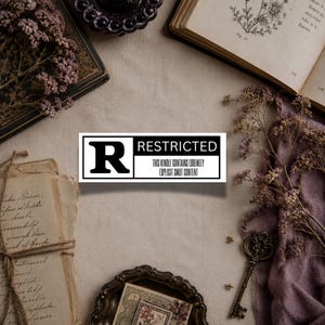 May include: A rectangular sticker with a white background and a black border. The left side features a large black letter R. The right side contains the word RESTRICTED in bold black text above the phrase THIS KINDLE CONTAINS EXTREMELY EXPLICIT SMUT CONTENT.