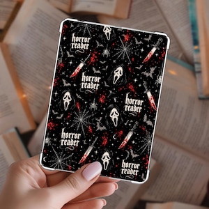 May include: A rectangular e-reader case featuring a black background with a repeating pattern of white ghost masks, bloody knives, spiderwebs, bats, and spiders. The text "horror reader" is printed in a white gothic font throughout the design.