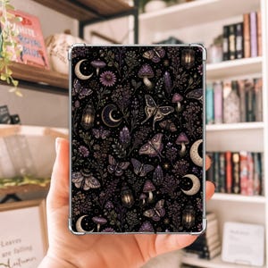 May include: A clear tablet case featuring a dark black background with a repeating pattern of purple mushrooms, various moths and butterflies, crescent moons, glowing lanterns, and sprigs of wildflowers and foliage across the entire surface.