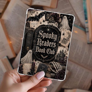 May include: A rectangular e-reader case featuring a dark, gothic-inspired collage design with the text Spooky Readers Book Club. The graphic includes illustrations of ghosts, a bat, a skull, a skeleton hand, a castle, and a lit candle.